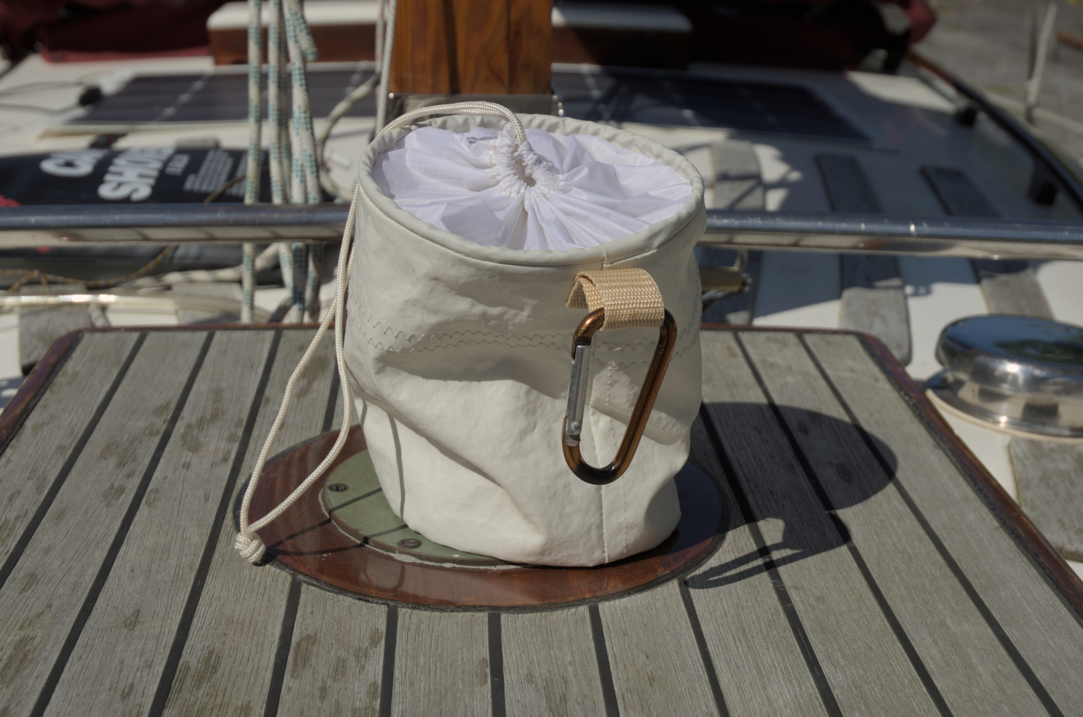 The pouch sitting. Turned to show the carabiner hook that attaches to a loop at the back.