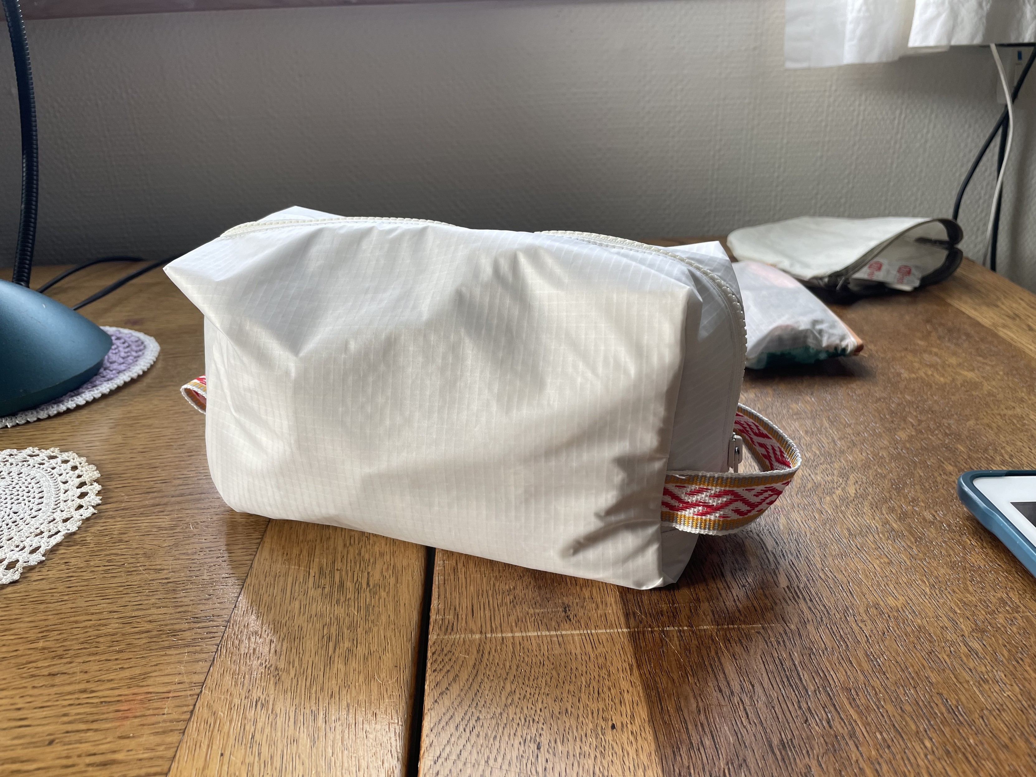 The bag from the side. It is a white nylon ripstop on the outside and sail on the inside. And it has a nice woven ribbon for the handle. My mom made that ribbon. 