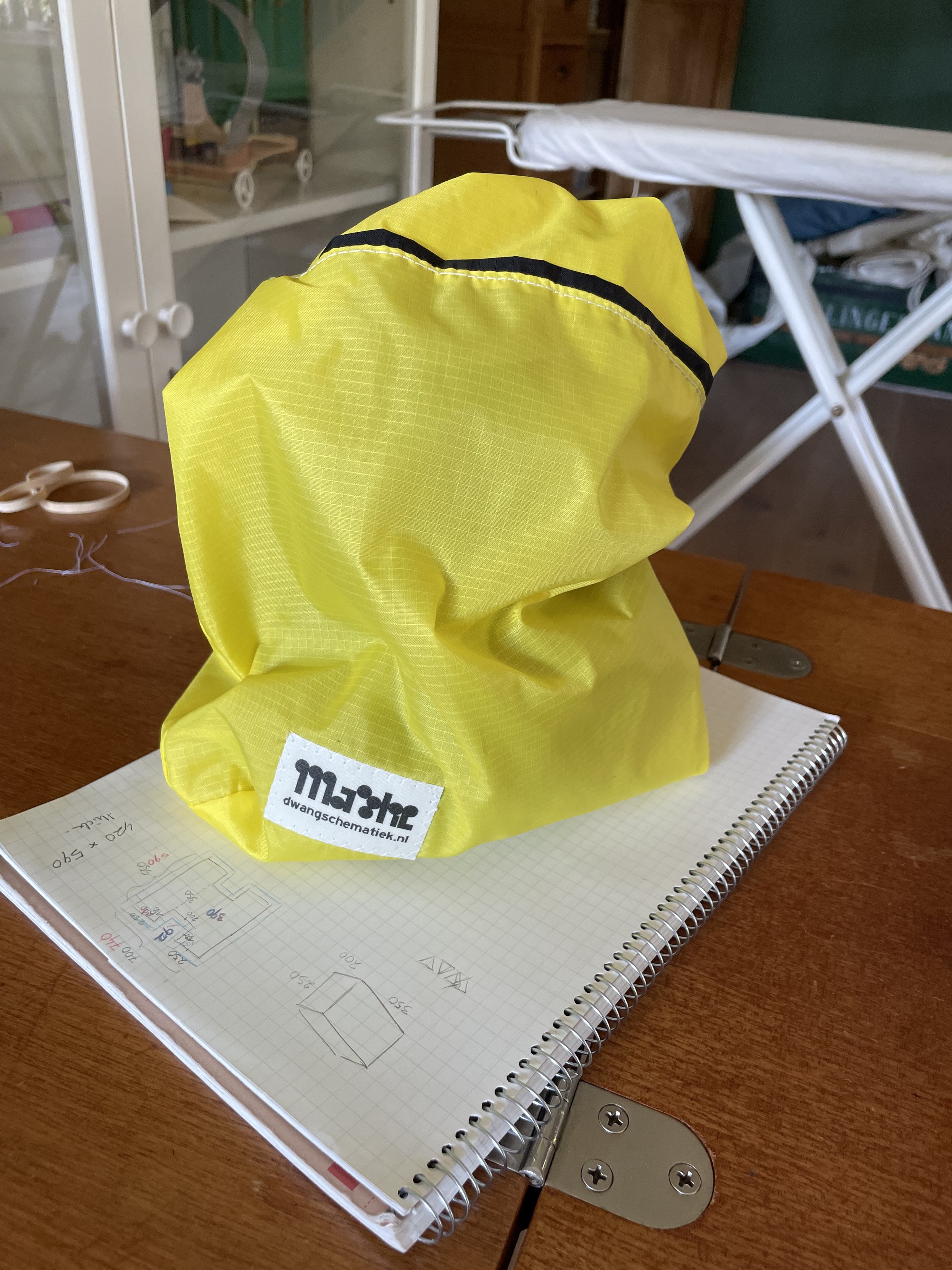 My yellow camera pouch with a black-on-white label stitched onto the lower corner. 
