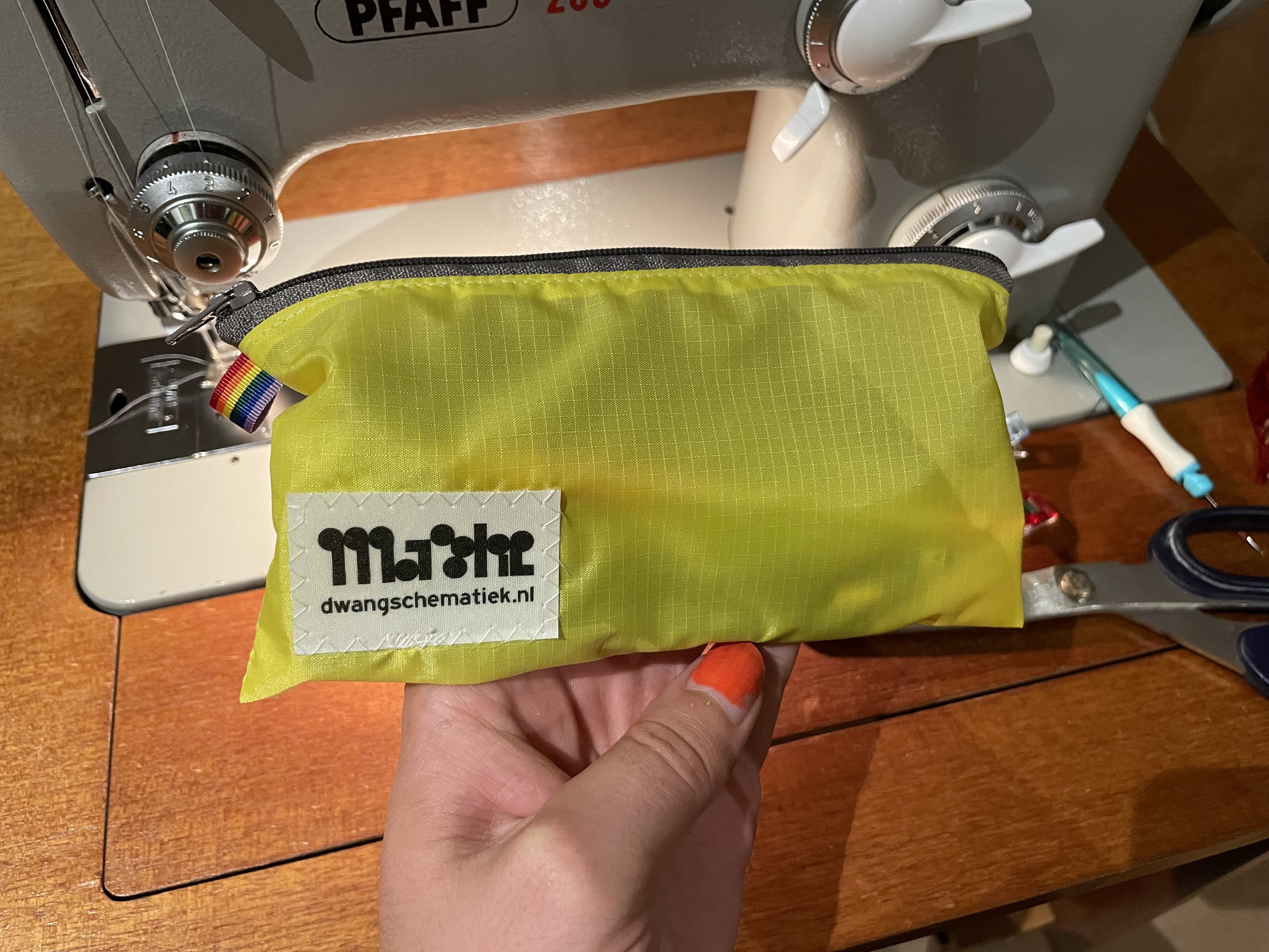 A yellow pencil pouch with a grey zipper and with my fabric label on it. 