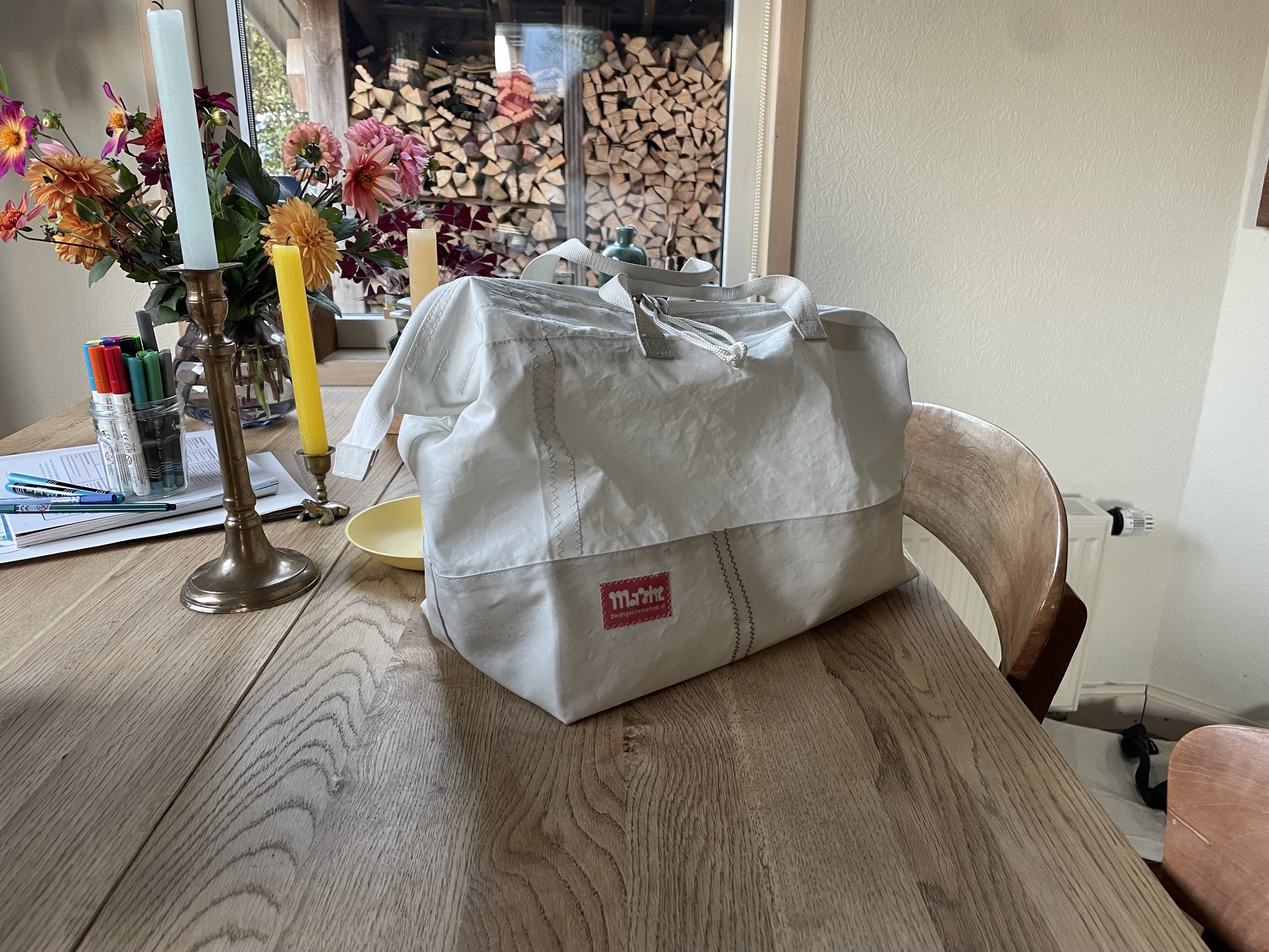A white bag sits on a table. It’s made from white sail cloth. 