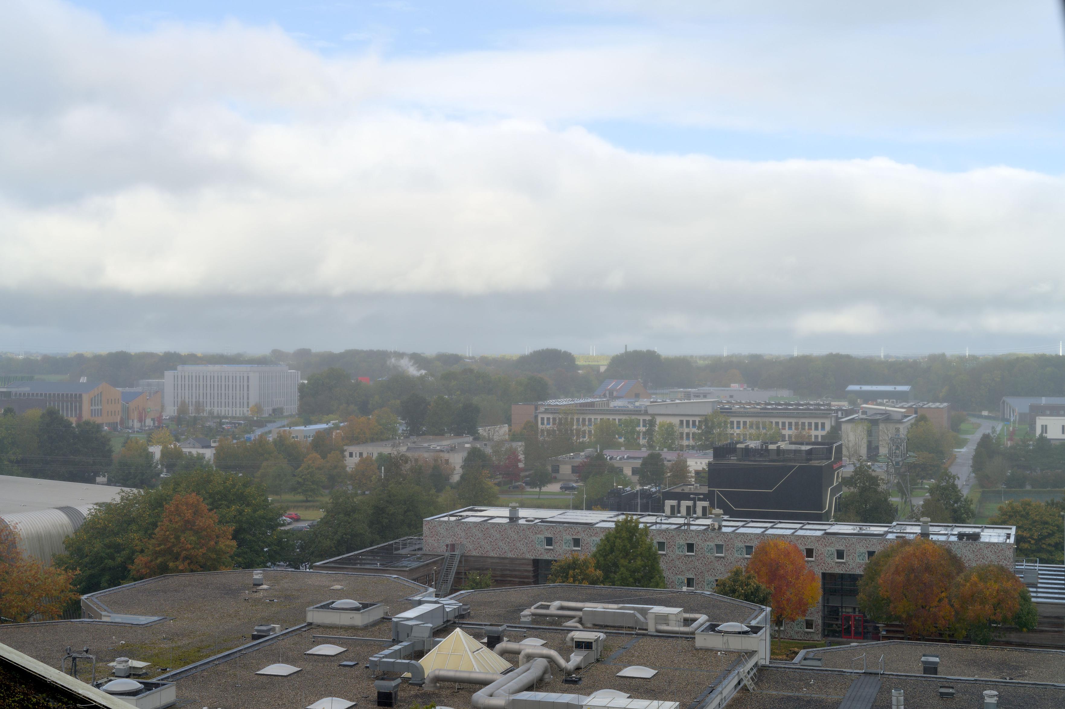 Slight hazy fog covers the campus and we see some sun striking the North–Groningen land in the distance.