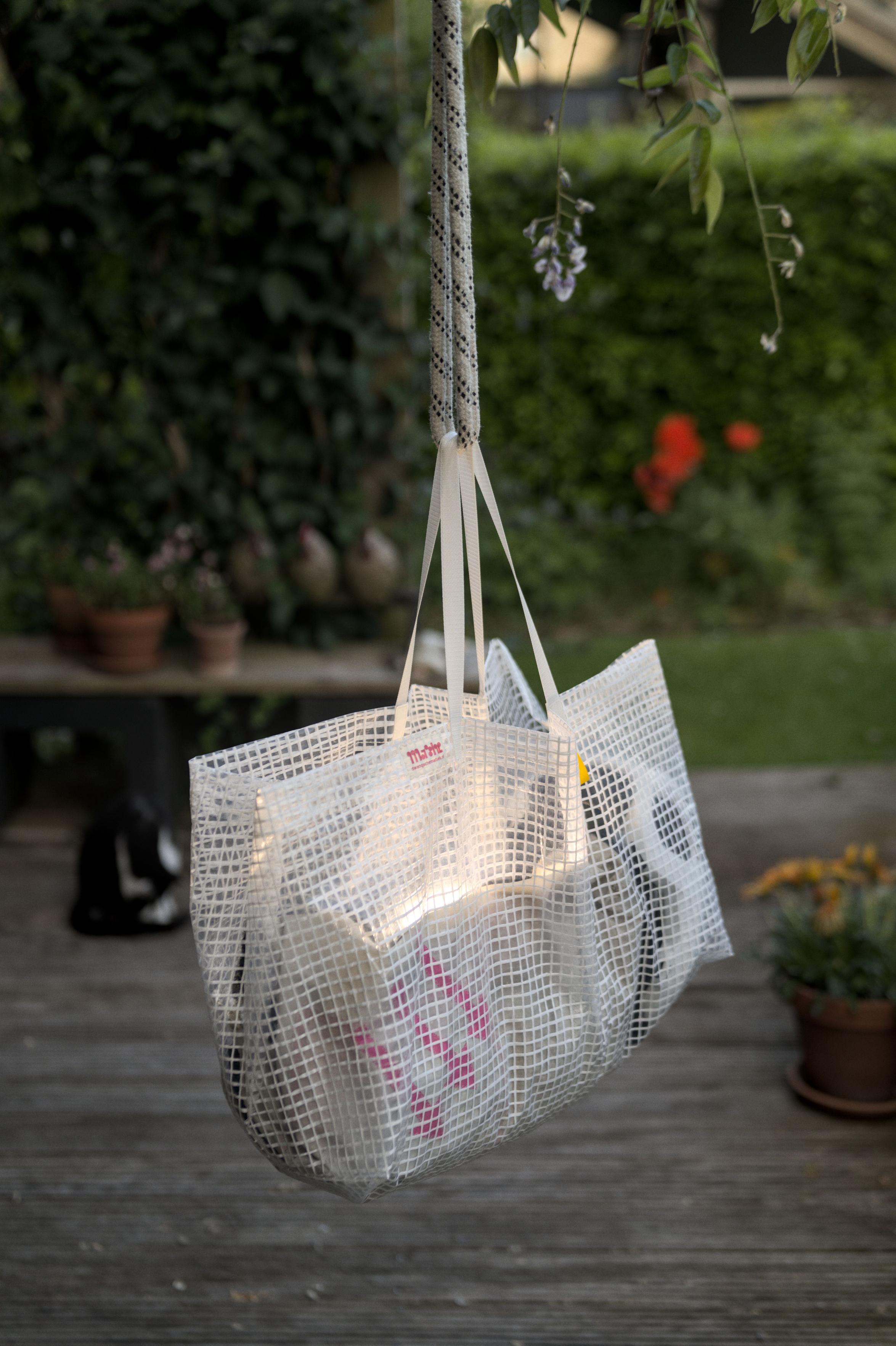Another view of the bag hanging in the garden. You
				 can see a black and white cat in the background.
